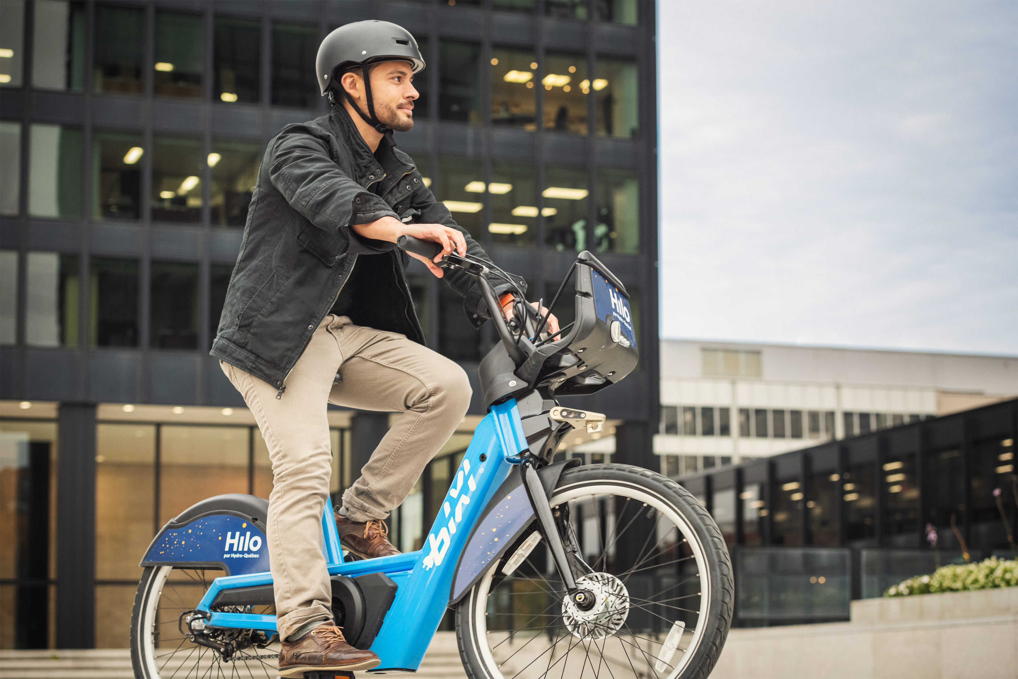 A young adult on a BIXI bike rolling around town